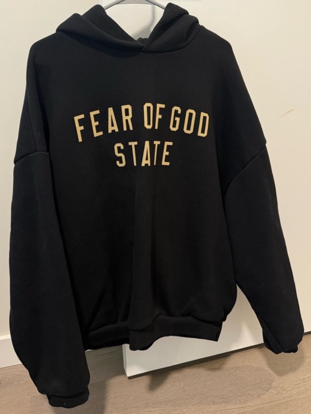 Fear of God Essentials Black Hoodie with Beige Lettering Accent